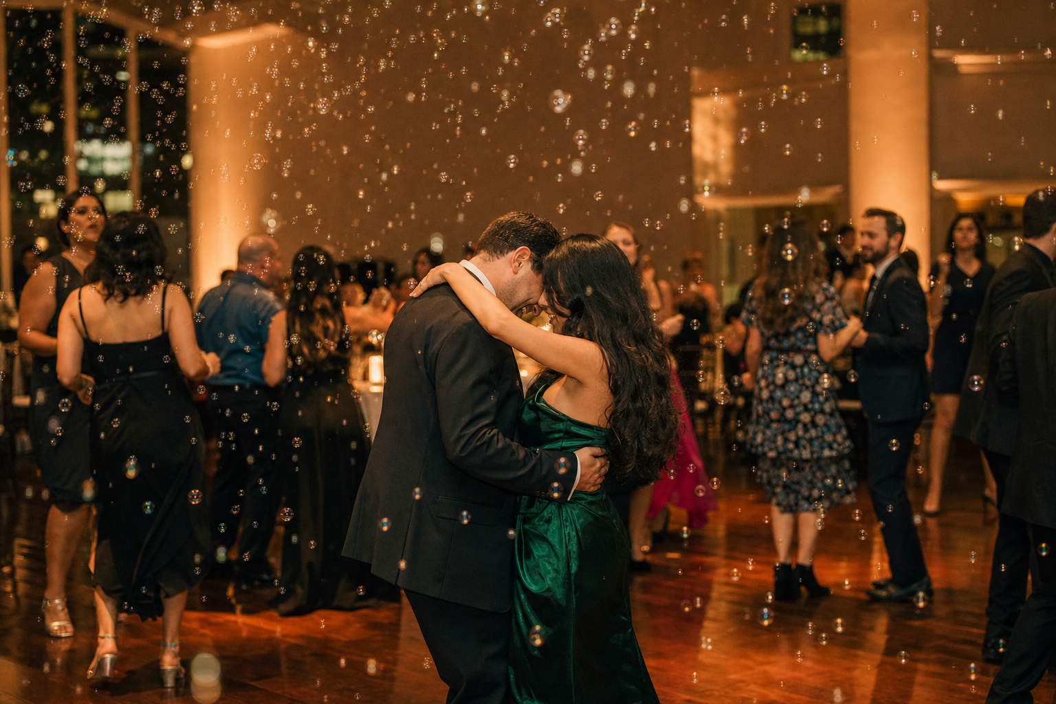 Indoor wedding reception with bubbles drifting across the dance floor under warm <a href=
